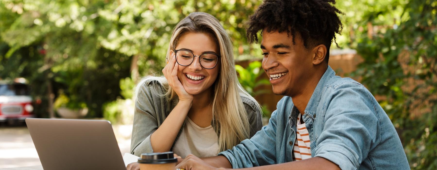 a man and a woman looking at a laptop